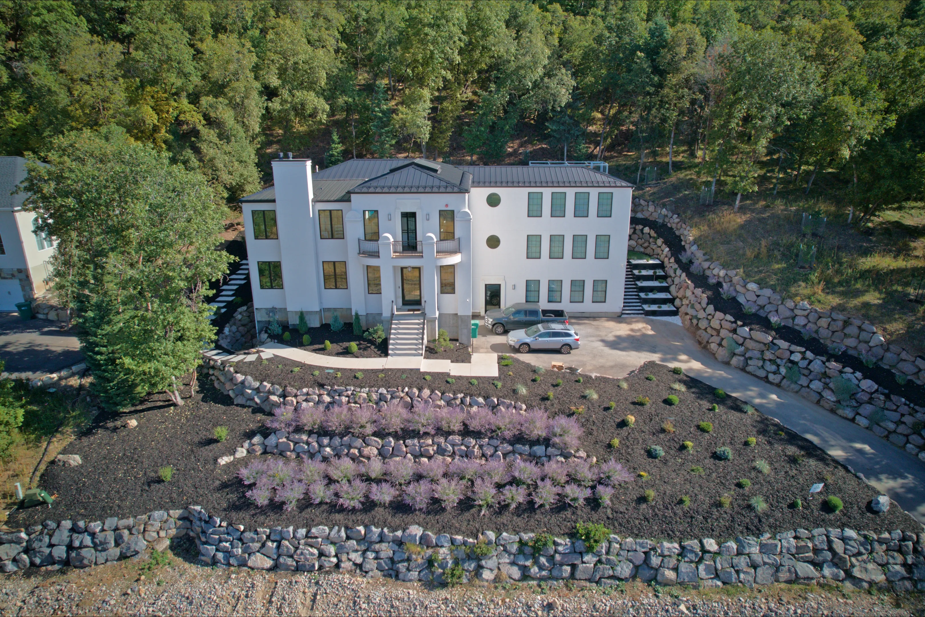 Aerial view of a large custom home with landscaped grounds