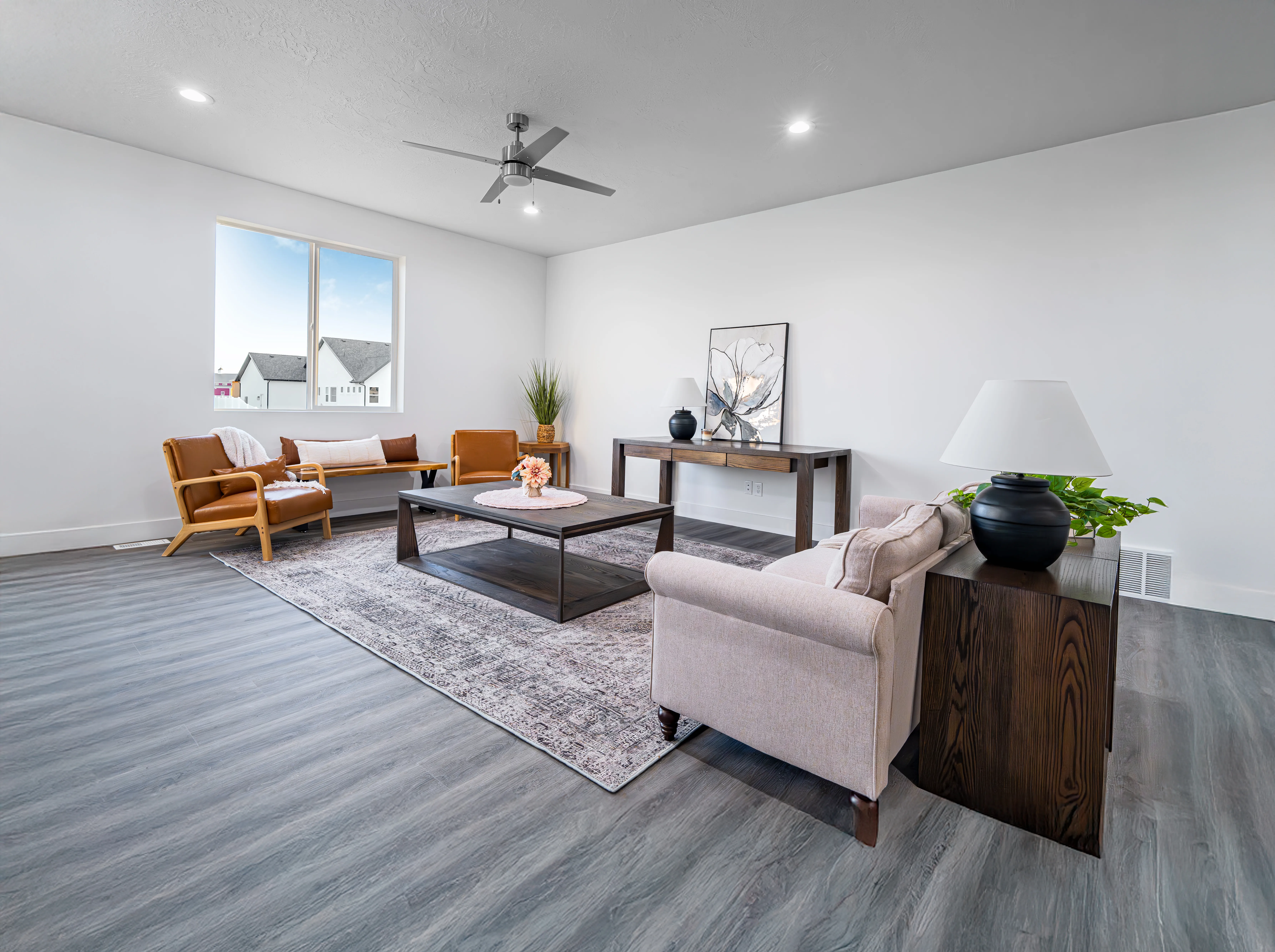 Staged living room with warm leather chairs, professionally photographed for a listing